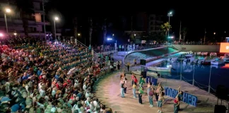 Πλήθος θεατών παρακολουθεί αγώνα μπάσκετ σε υπαίθριο γήπεδο τη νύχτα